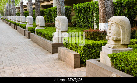 Beijing, China - Apr. 18, 2018: Multiple sculpture of woman with varying hand poses on sidewalk, Beijing, China. Stock Photo