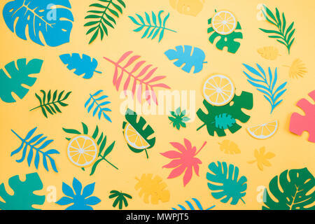 Tropical leaves pattern. Blue, green and pink leaves on a bright yellow background. Summer vacation concept. Stock Photo