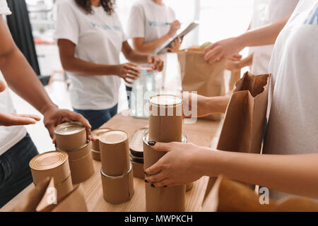 cropped shot of volunteers sorting tin cans with food for charity Stock Photo