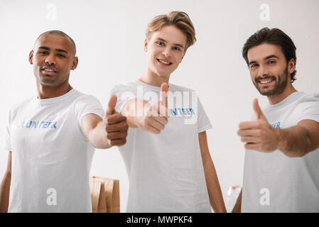 group of multiethnic volunteers showing thumbs up Stock Photo