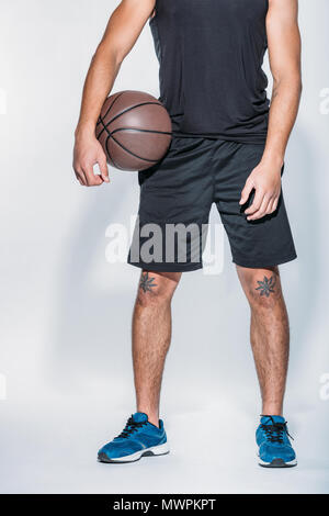 cropped image of basketball player standing with ball Stock Photo
