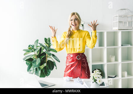 stressed businesswoman gesturing and yelling in modern office Stock Photo