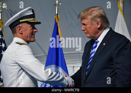 President Donald Trump congratulates Adm. Paul Zukunft during a change of command ceremony at Coast Guard Headquarters in Washington, D.C., June 1, 2018. During the ceremony Adm. Karl Schultz relieved Zukunft to become the 26th commandant of the Coast Guard. U.S. Coast Guard photo by Petty Officer 1st Class Patrick Kelley. Stock Photo