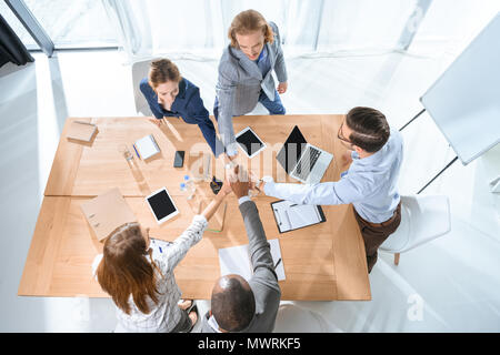 business team shaking hands over table at office space Stock Photo