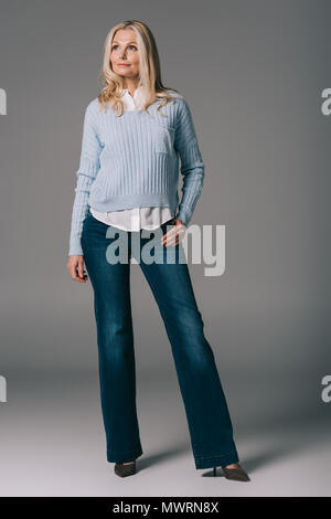 beautiful mature woman in bell-bottoms on grey Stock Photo