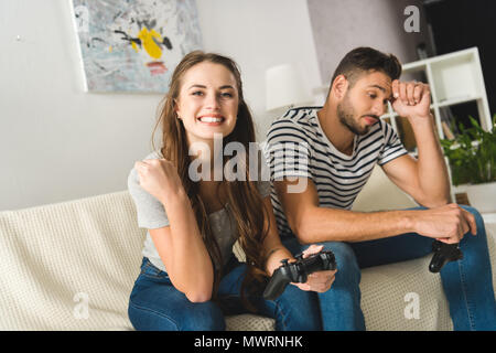 woman celebrating victory in computer game over boyfriend Stock Photo