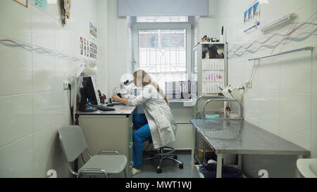 Doctor woman working with a microscope in Laboratory. Female scientist looking through a microscope in lab. Scientist using a microscope in a laboratory. Stock Photo