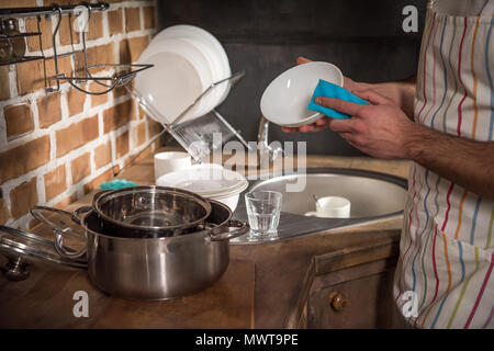 cropped image of man washing dishes at kitchen Stock Photo