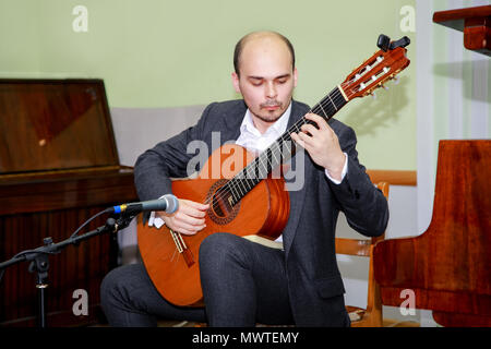 Concert performers playing guitar. Young guitarist plays on stage. Stock Photo