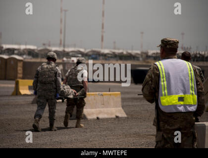 Members of the 387th Expeditionary Security Forces Squadron evacuate a simulated casualty after a vehicle borne improvised explosive device detonation as a wing inspection team member evaluates them during a force protection condition delta exercise at an undisclosed location in Southwest Asia, April 27, 2017. The 387th Air Expeditionary Group conducted a force protection condition delta exercise to demonstrate base defense capabilities in response to increased terrorist threat levels. Stock Photo