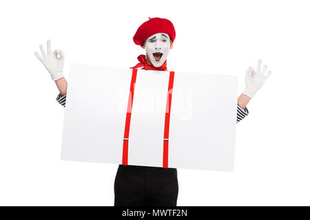 happy mime holding empty board under suspenders and showing ok sign isolated on white Stock Photo