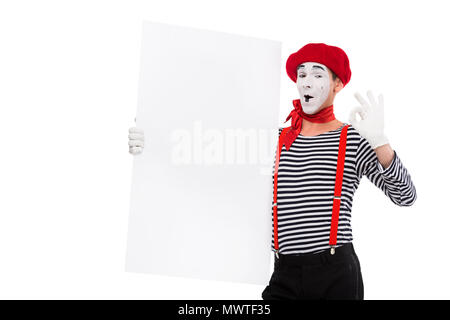 happy mime holding empty board and showing ok sign isolated on white Stock Photo