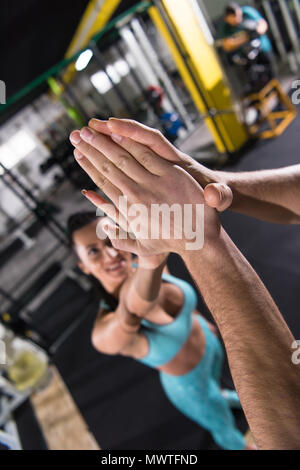 group of young athletes making high five after hard exercise at cross fitness gym Stock Photo