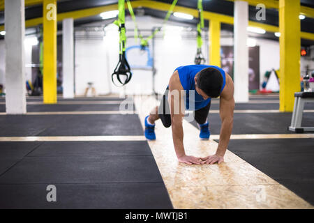 Young strong man doing pushups  at cross fitness gym Stock Photo