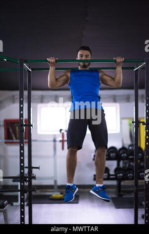 young muscular man doing pull ups on the horizontal bar as part of Cross fitness Training Stock Photo