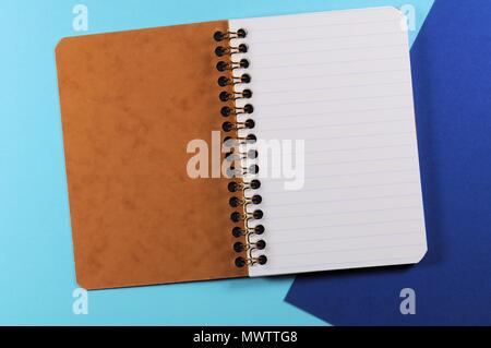 Empty open striped notebook close up on blue background Stock Photo
