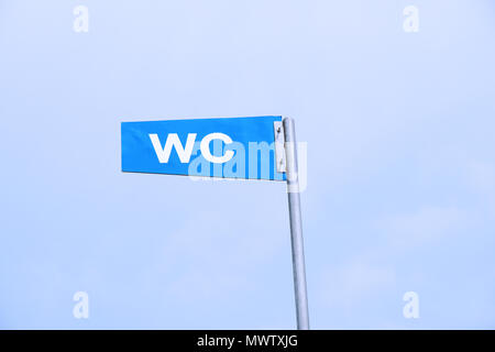 WC sign for public toilet or restroom against sky Stock Photo