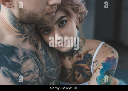 young tattooed girl hugging her boyfriend Stock Photo