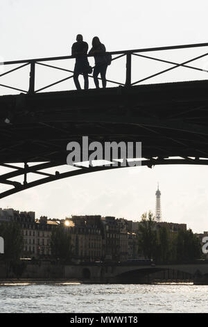 Silhouette of a couple standing on Pont des Arts bridge, over the Seine River in Paris, France. Stock Photo