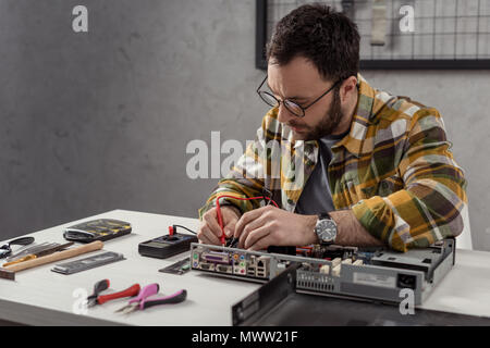 repairman using multimeter while fixing computer Stock Photo