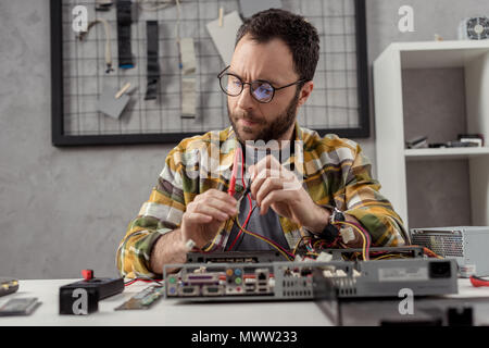 man using multimeter while fixing pc Stock Photo