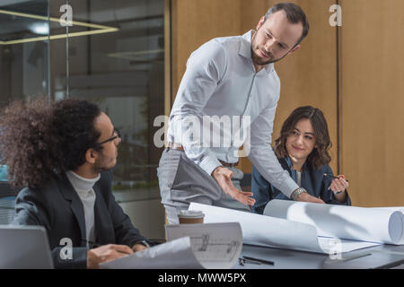 team of young architects working with building plans Stock Photo