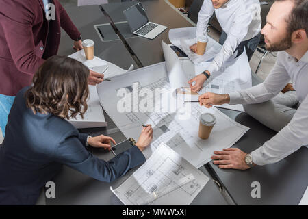 high angle view of group of architects working together on building plans at office Stock Photo
