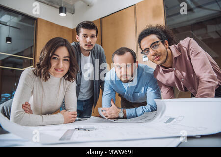 group of successful architects working on plans together at office Stock Photo