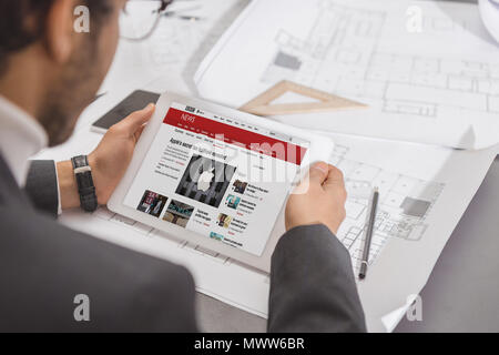 cropped shot of young architect using tablet at workplace with bbc website on screen Stock Photo