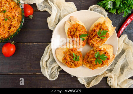 Squash caviar on a crispy baguette on a dark wooden table. Sandwiches with stewed vegetables. Vegan appetizer. Stock Photo