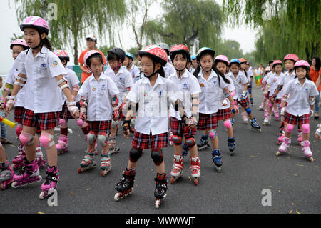 Beijing, China. 26th July, 2014. File photo taken on July 26, 2014 shows children practicing roller-skating on the Bai Causeway at West Lake scenic spot in Hangzhou, capital of east China's Zhejiang Province. This set of 41 old photos, taken from 1978 to 2018 by year, pictorially record childhood moments of Chinese kids in the past four decades. Credit: Ju Huanzong/Xinhua/Alamy Live News Stock Photo