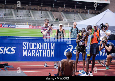 Stockholm, Sweden. 2nd June 2018. The winner of the 40th Stockholm marathon, Lawi Kiptui from Kenya, gives the runner-up, Dominic Kimwetich Kangor also from Kenya a sip of the beer the winner got after the race. The third-placed runner, Stephen Kiplimo also from Kenya, relaxing after the race beside them Credit: Jari Juntunen/Alamy Live News Credit: Jari Juntunen/Alamy Live News Stock Photo