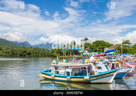 Colorful tour boats anchoring at the port of Paraty with view to the Serra da Bocaina mountain range, Rio de Janeiro, Brazil, South America Stock Photo