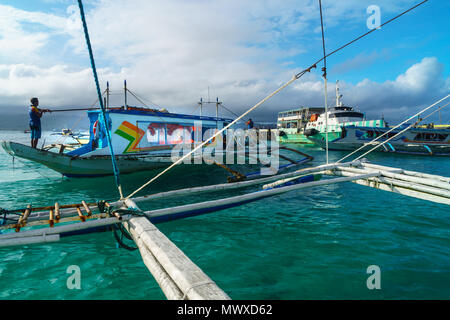 Bangkas (outrigger canoes) and the old ferry compete for landing space at the harbour, Borocay Island, Philippines, Southeast Asia, Asia Stock Photo