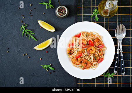 Pasta spaghetti with shrimps, tomato and parsley. Healthy meal. Italian food. Top view. Flat lay Stock Photo