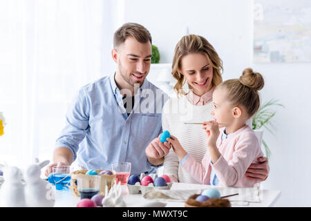 Parents and daughter painting Easter eggs Stock Photo