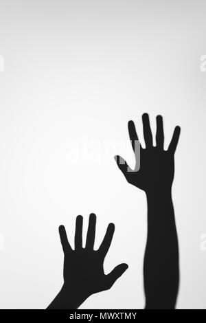 scary mysterious shadows of human hands on grey Stock Photo
