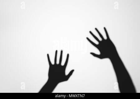 spooky mysterious shadows of human hands on grey Stock Photo