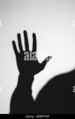 strange blurry shadow of human hand on grey Stock Photo