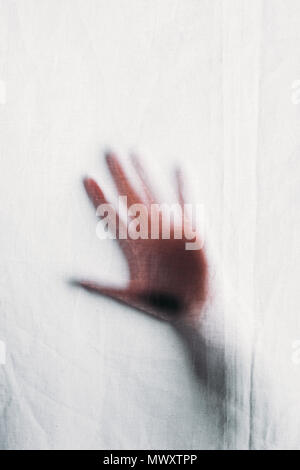 blurry silhouette of human hand touching veil Stock Photo