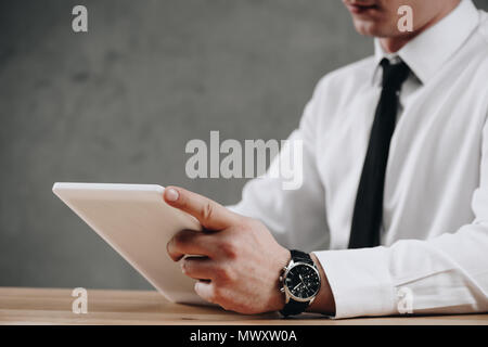 cropped shot of businessman using digital tablet on grey Stock Photo