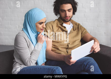 muslim couple using tablet in living room Stock Photo