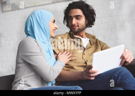 smiling muslim couple using tablet at home Stock Photo