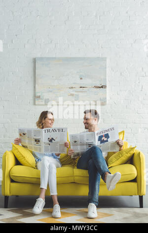 Stylish businessman with girlfriend reading newspapers about business and travel Stock Photo