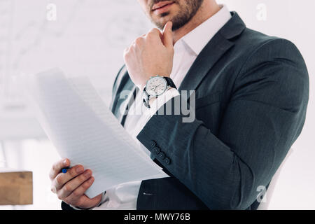 cropped image of businessman reading documents in office Stock Photo