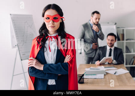 super businesswoman in cape standing with crossed arms in office Stock Photo