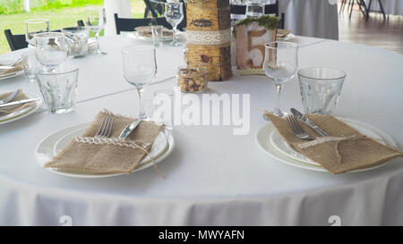 Banquet decorated table, with cutlery. Serving of a festive table, plate, napkin, knife, fork. Table setting decoration. Romantic Dinner or other events. Stock Photo