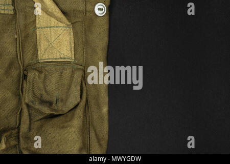 Very old green military bag for gas mask on black background surface with free space Stock Photo