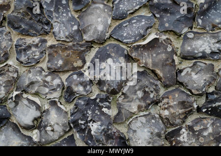 A detailed view of a wall constructed from flint, suitable for use as a background or texture. Stock Photo