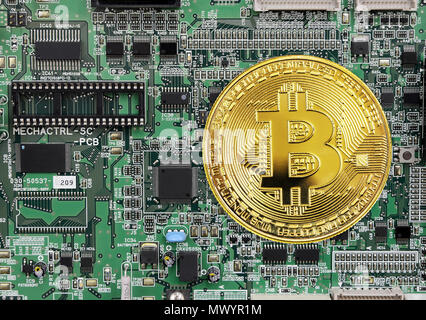 Golden coin of bitcoin crypto currency, new digital money in cyber world, on the background of electronic circuit board Stock Photo